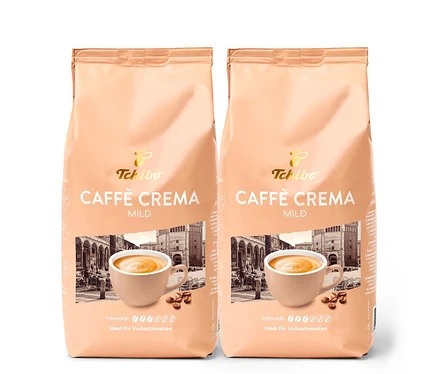 Deux paquets de Caffè Crema Mild en grains – 2x 1 kg de Tchibo. L'emballage montre une tasse de café et un bâtiment.