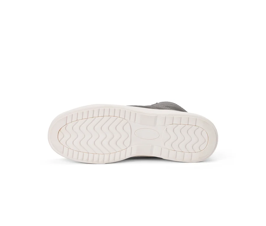 Semelle blanche d'une chaussure grise, montrant un motif de bande de roulement ondulé et des bords texturés.