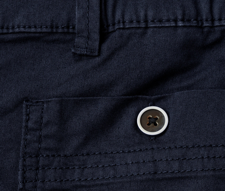 Gros plan d'un bermuda Street One « Yulius » bleu marine, montrant une poche avec un bouton rond marron à bord blanc.