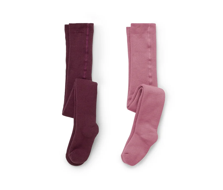 Deux paires de collants posées à plat sur un fond blanc, l'une bordeaux foncé, l'autre rose poudré.