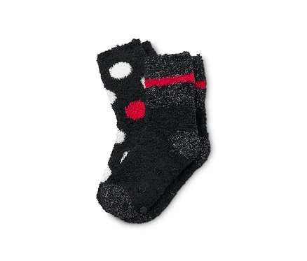 Deux paires de chaussettes douces noires. Une paire est à pois blancs et rouges, l'autre à rayures rouges.
