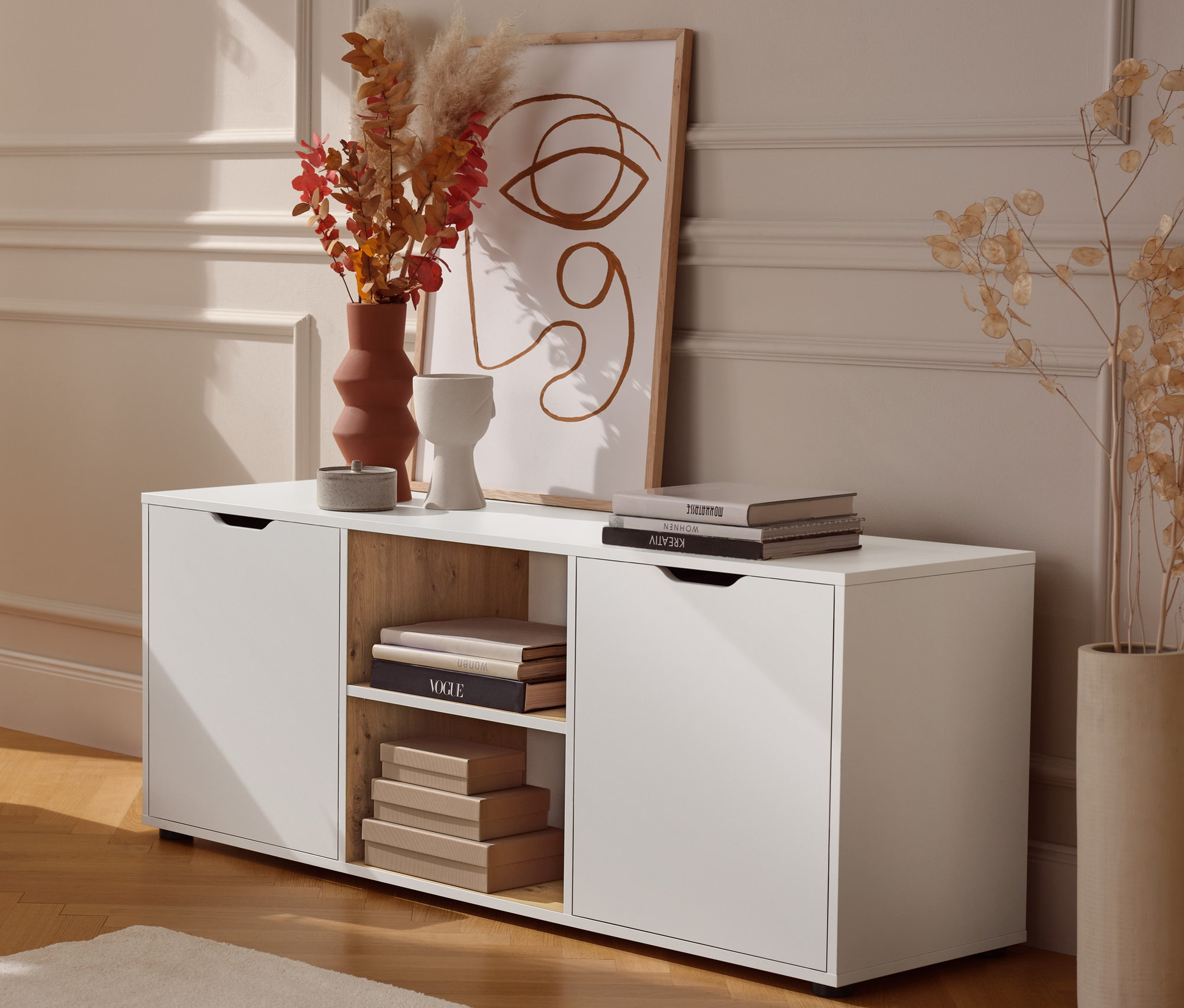 Une table d'appoint en métal est placée à côté d'un buffet avec tiroirs.