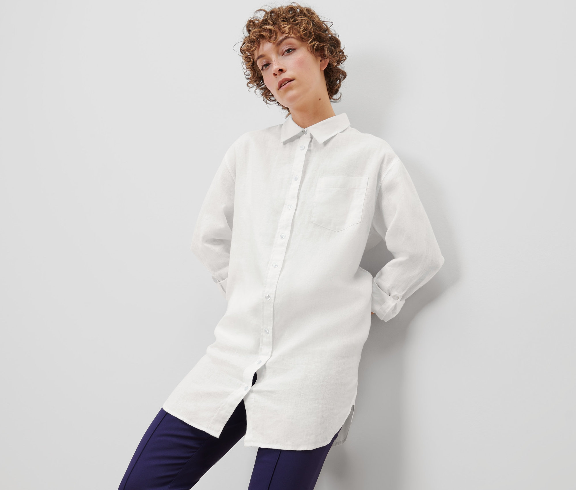 Femme posant en chemisier en lin blanc.