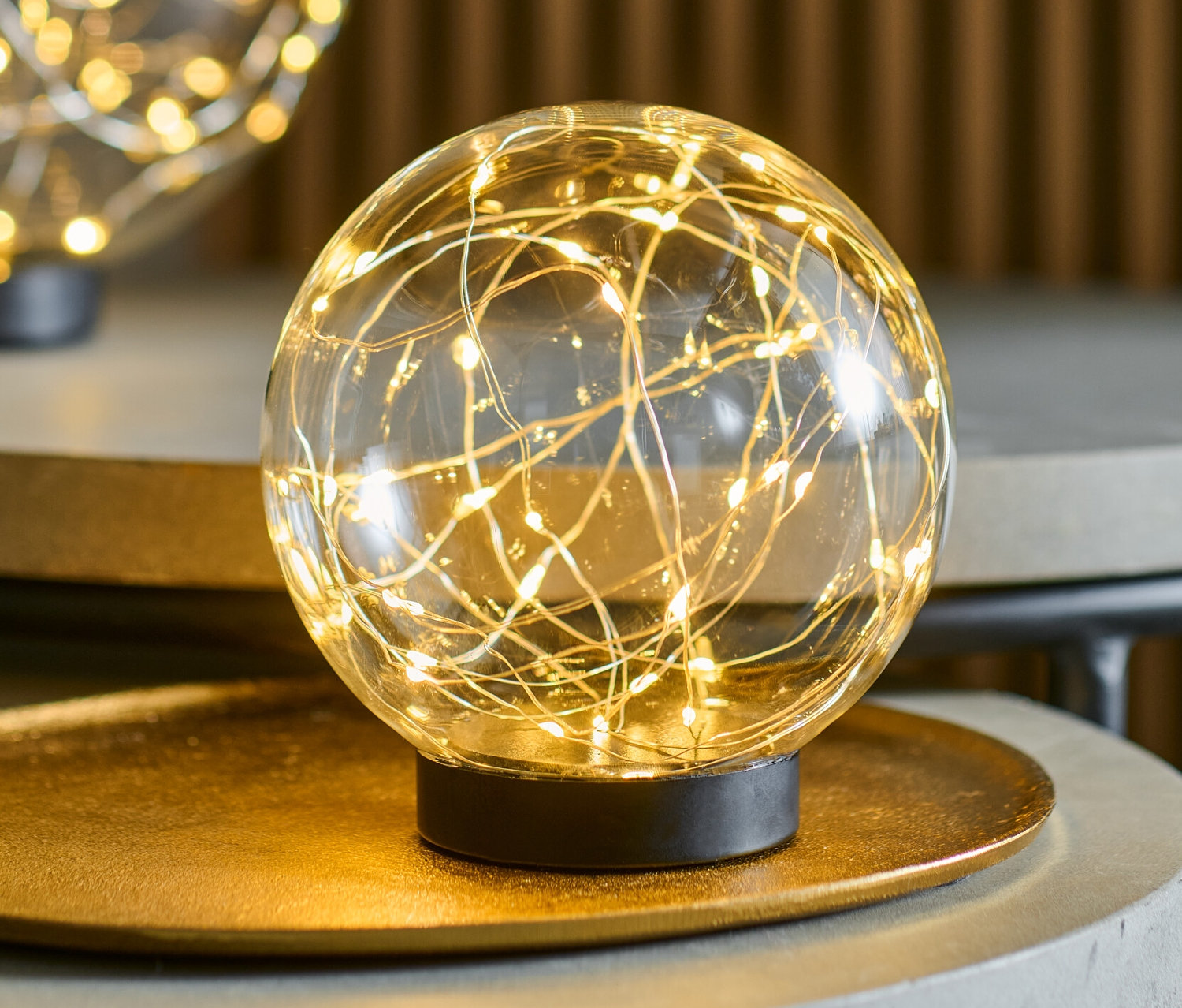 Deux boules de verre à LED d'environ 15 cm de diamètre chacune, posées sur des tables grises.