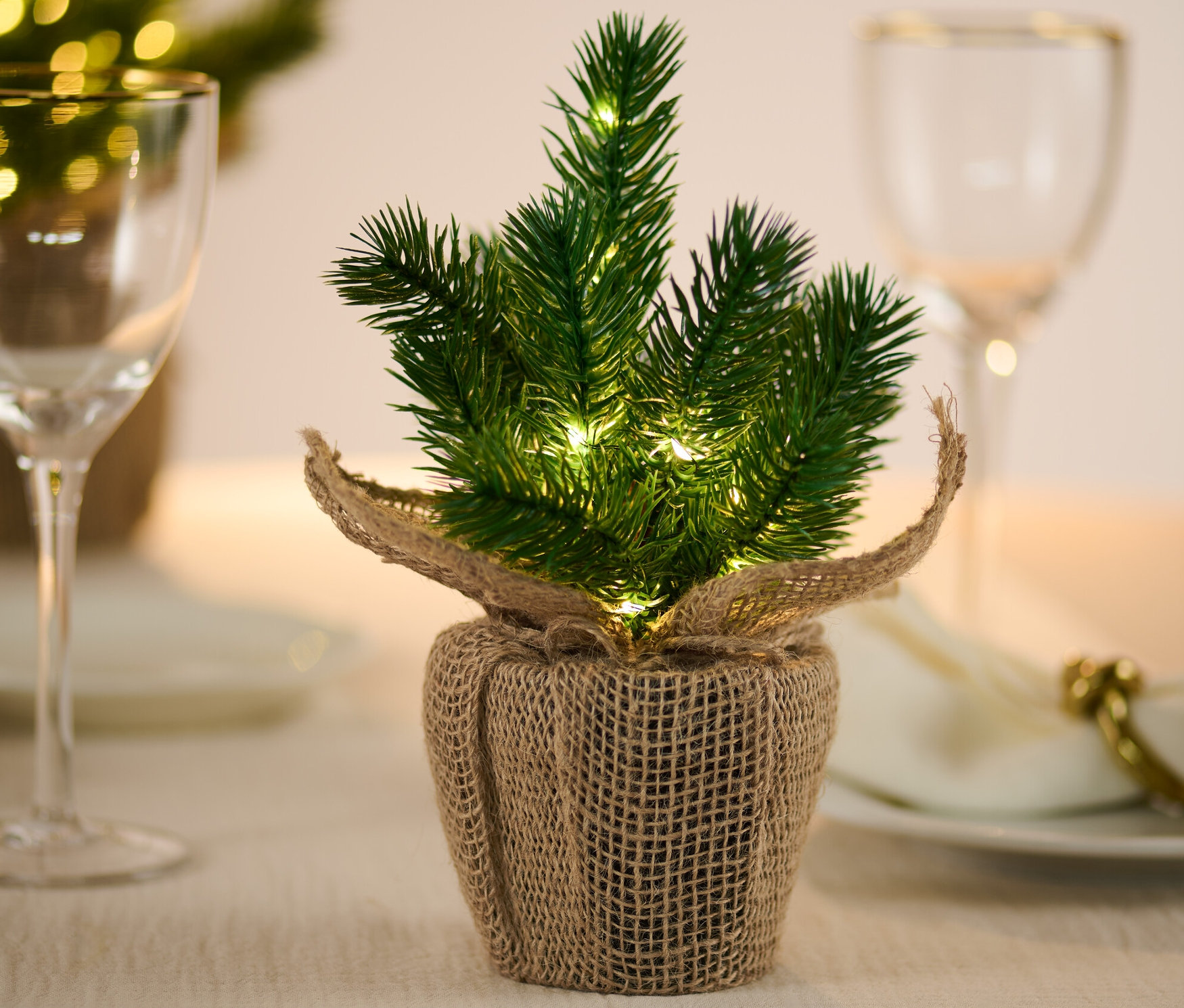 Un petit sapin à LED est posé sur une table.