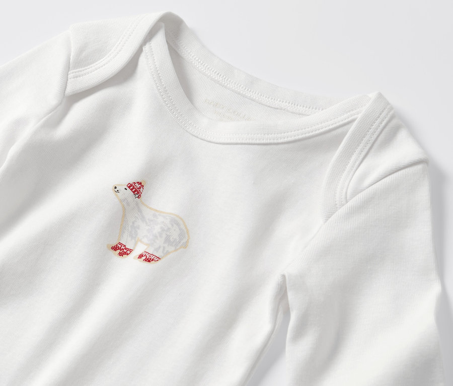Gros plan sur un body enfant à manches longues orné d'un motif d'ours avec un bonnet et des chaussettes rouges.