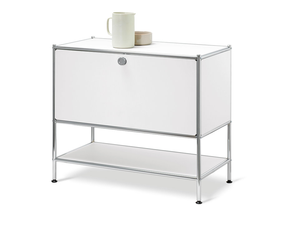 Buffet bas « CN3 » blanc avec 1 abattant. Un pichet en céramique et un bol sont posés sur le dessus.