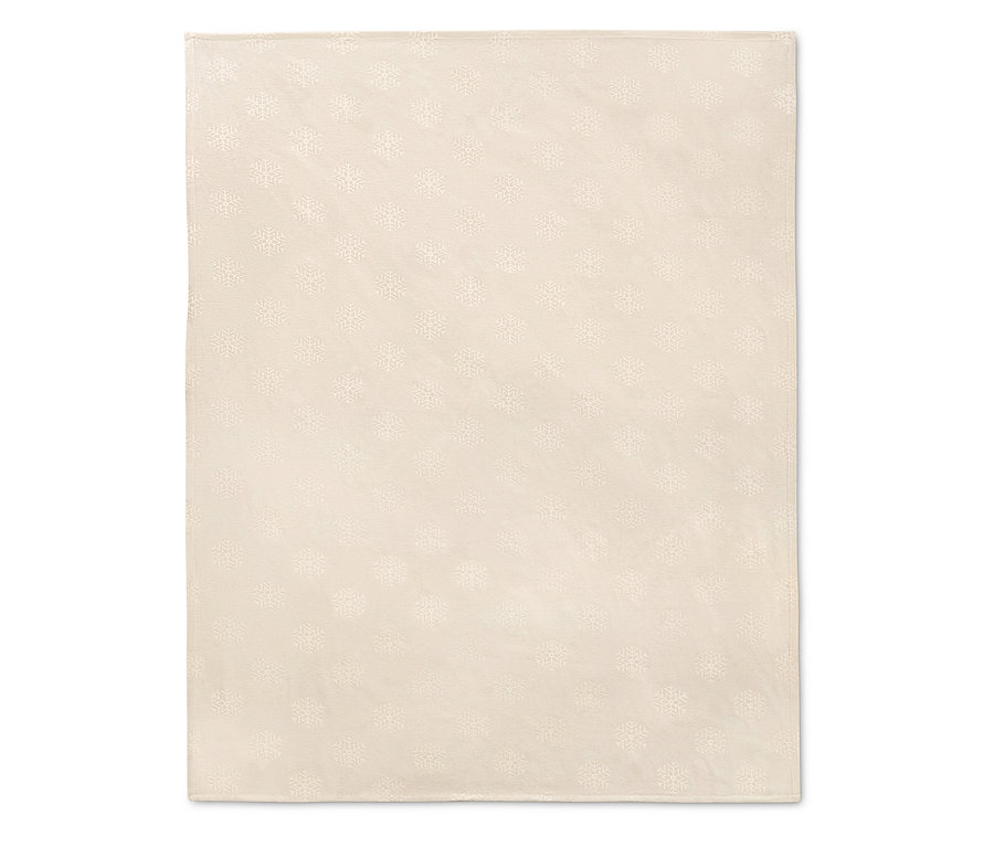 Une nappe en jacquard crème avec un motif de flocons de neige.