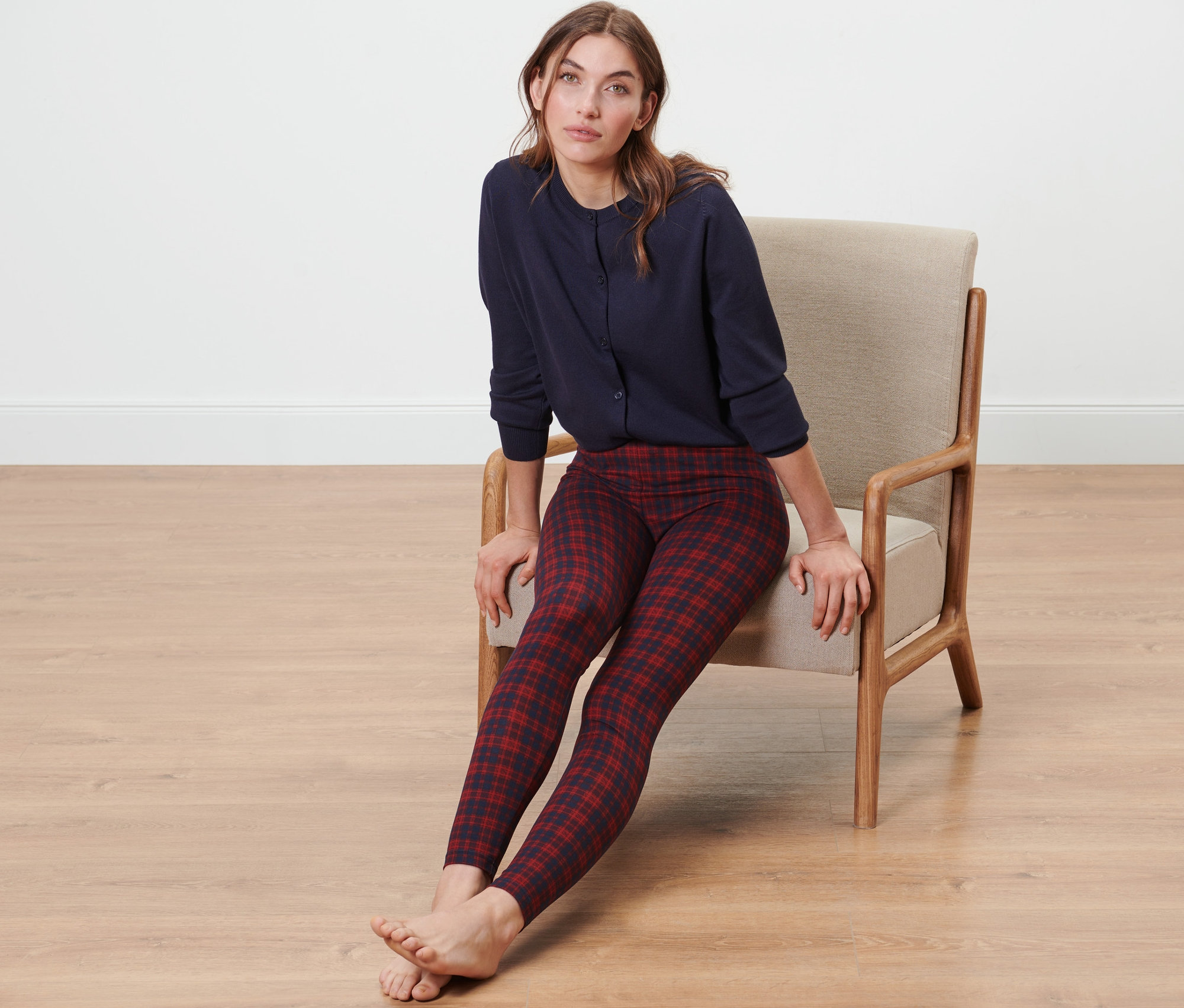 Une femme est assise dans un fauteuil et porte un legging douillet et un haut bleu.