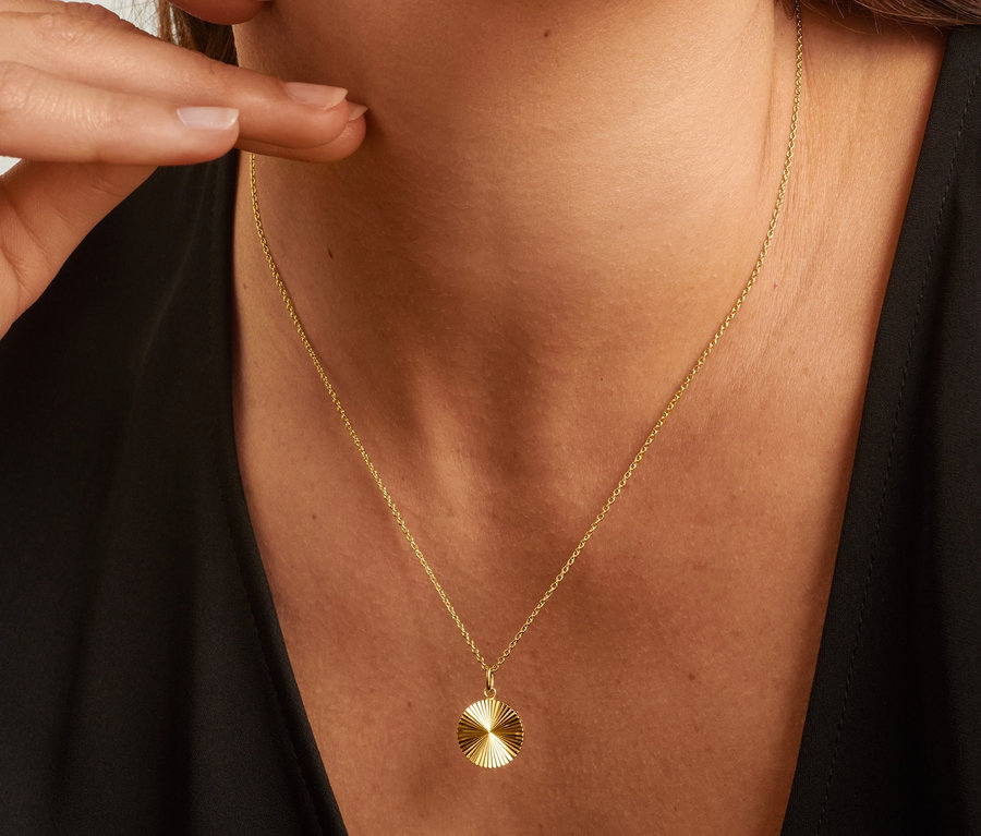 Femme avec chaîne argent 925 coupe solaire et clou d'oreille argent 925 pyramide.