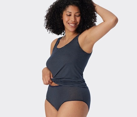 Une femme pose en débardeur et 2 midi slips SCHIESSER avec modal, bleu foncé, à rayures.