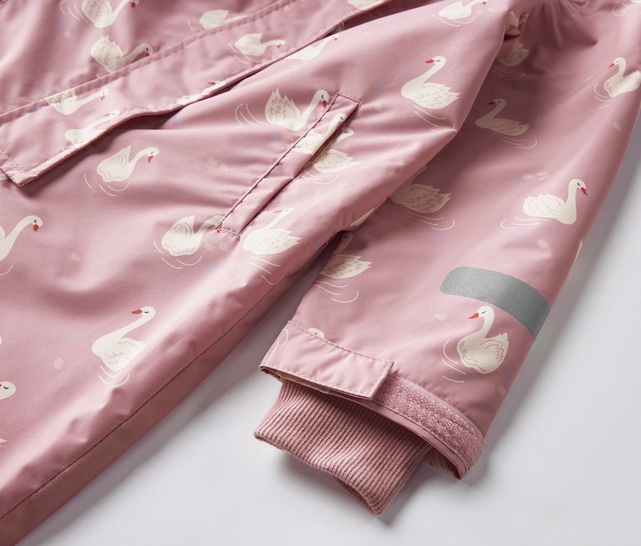 Gros plan sur une combinaison de pluie pour enfant avec un motif de cygnes.
