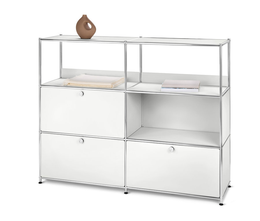 Commode en métal blanche « CN3 » à 2 abattants et 1 tiroir. Un vase brun et des vêtements pliés sont posés dessus.