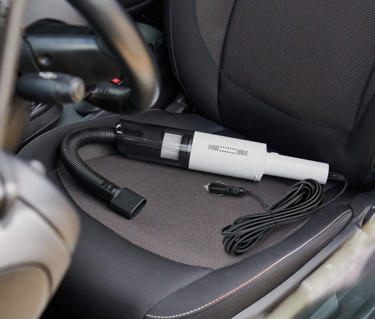 Un aspirateur de voiture est posé sur un siège auto.