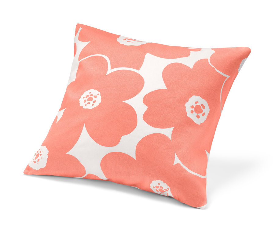 Une housse de coussin décoratif avec un motif floral corail sur fond blanc.