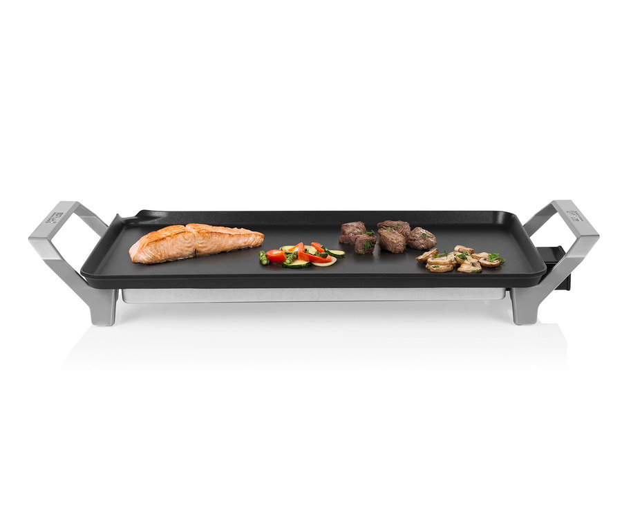 Du saumon, des légumes, du bœuf et des champignons sont grillés sur un gril teppanyaki.