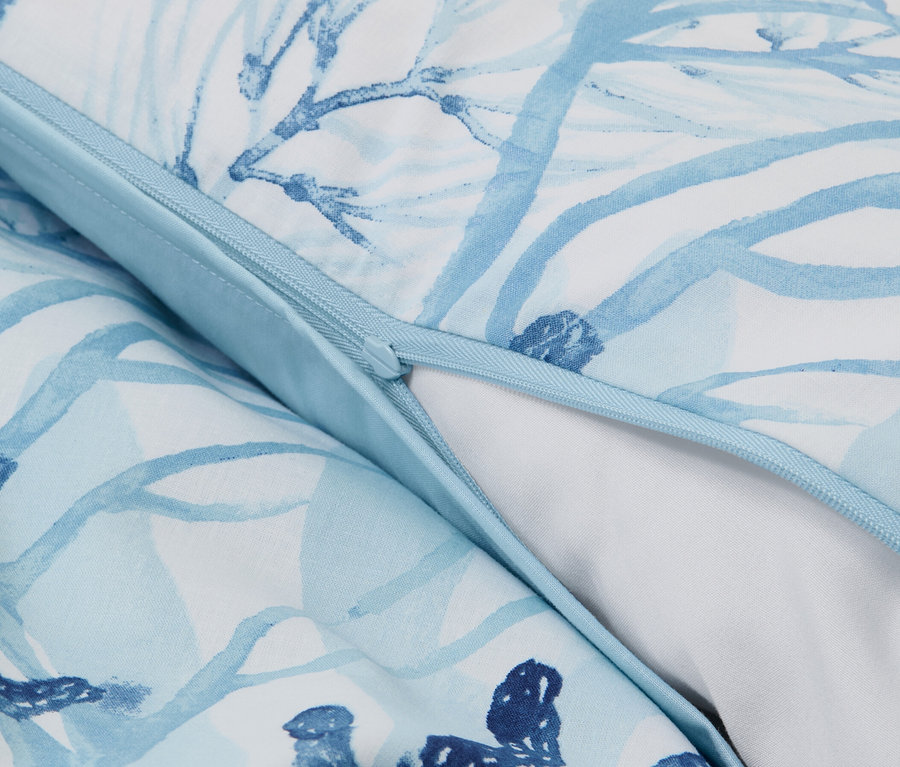 Détail de la parure de lit en renforcé de taille standard avec un motif floral bleu et blanc et une fermeture éclair.