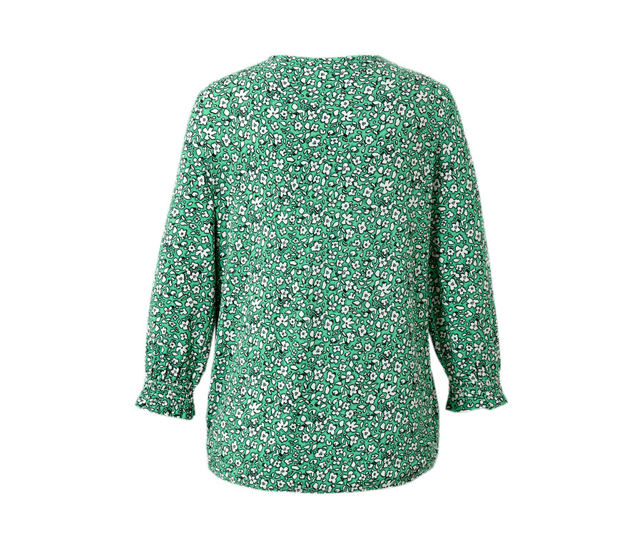 Blouse imprimée verte avec de petites fleurs blanches.