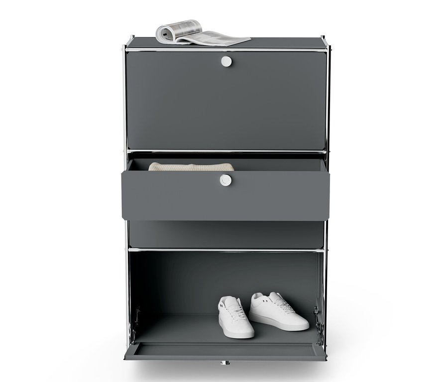 Commode en métal gris « CN3 » avec 2 abattants, 2 tiroirs, un journal sur le dessus et des chaussures à l'intérieur.