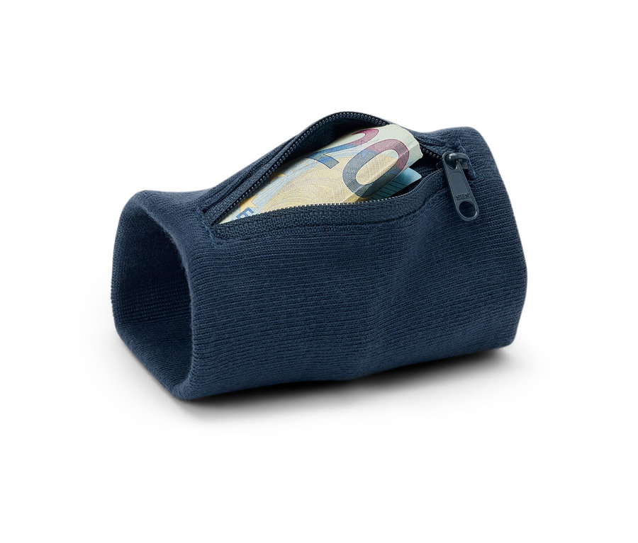 Gros plan d'un porte-monnaie de sécurité bleu marine pour poignet contenant un billet de vingt euros, posé sur un fond blanc.