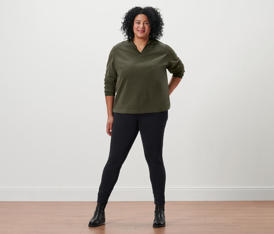 Femme posant en sweat-shirt avec col polo, jegging et bottines en cuir.