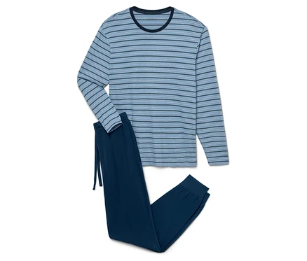 Un pyjama rayé à manches longues et un pantalon bleu marine sont posés sur un fond blanc.