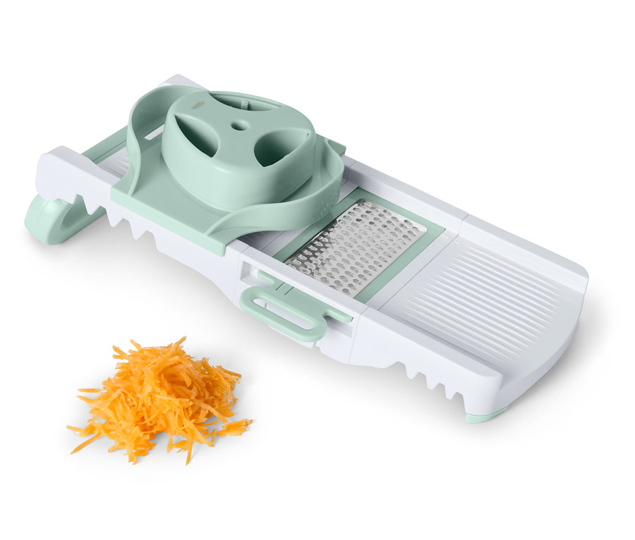 Mandoline avec un tas de carottes râpées.