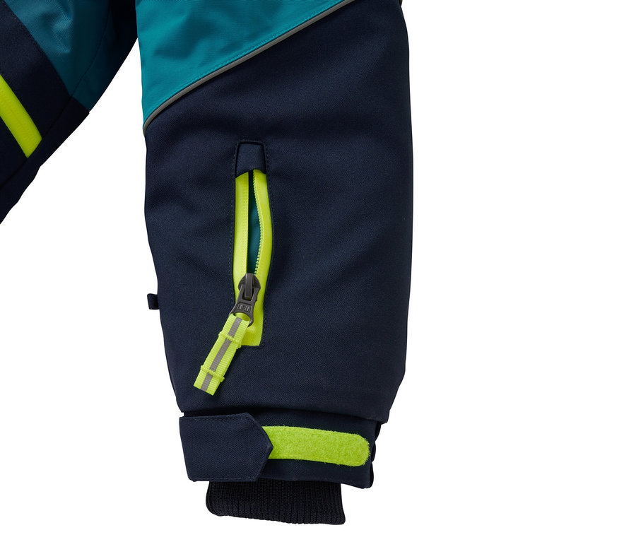 Détail d'une veste bleu-turquoise avec des fermetures éclair et des rayures jaunes.