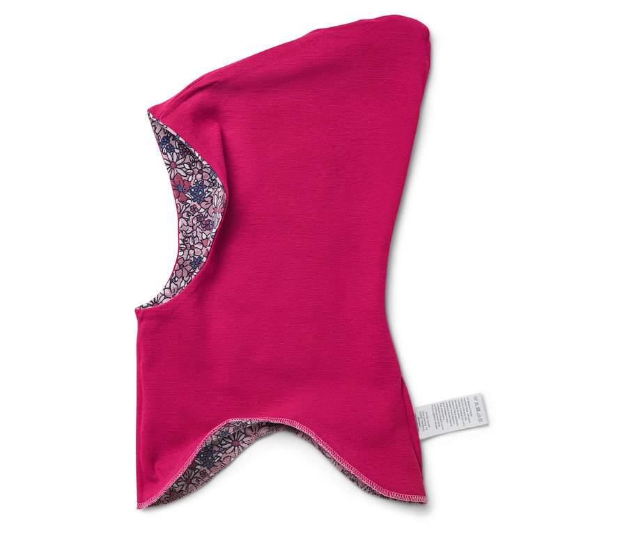Une cagoule rose avec une doublure florale repose sur un fond blanc.