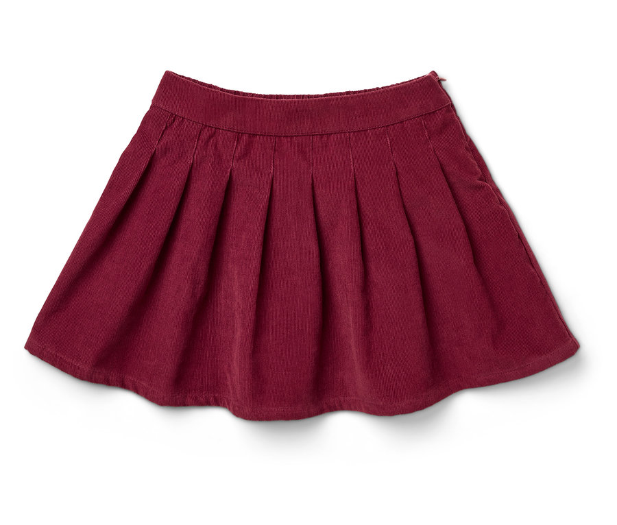 Une jupe plissée en velours côtelé bordeaux repose sur un fond blanc.