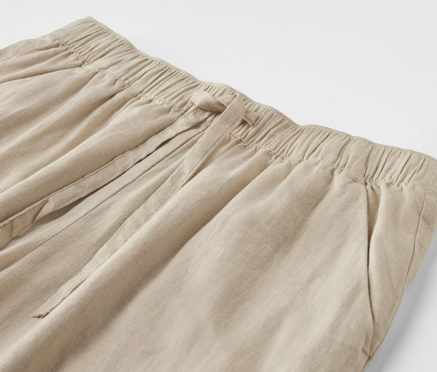 Gros plan d'un pantalon en lin de couleur sable.
