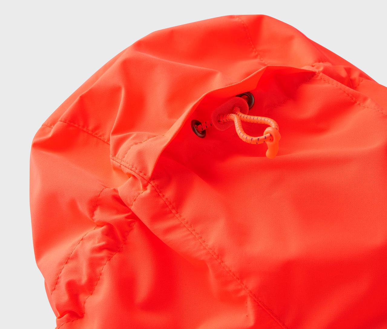 Gros plan sur la capuche d'une veste orange avec cordon de serrage.