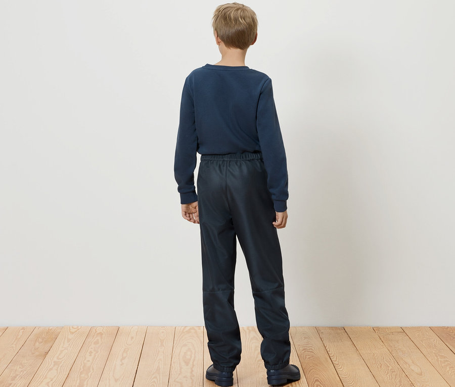Un garçon, vu de dos, porte un pantalon softshell pour enfant.