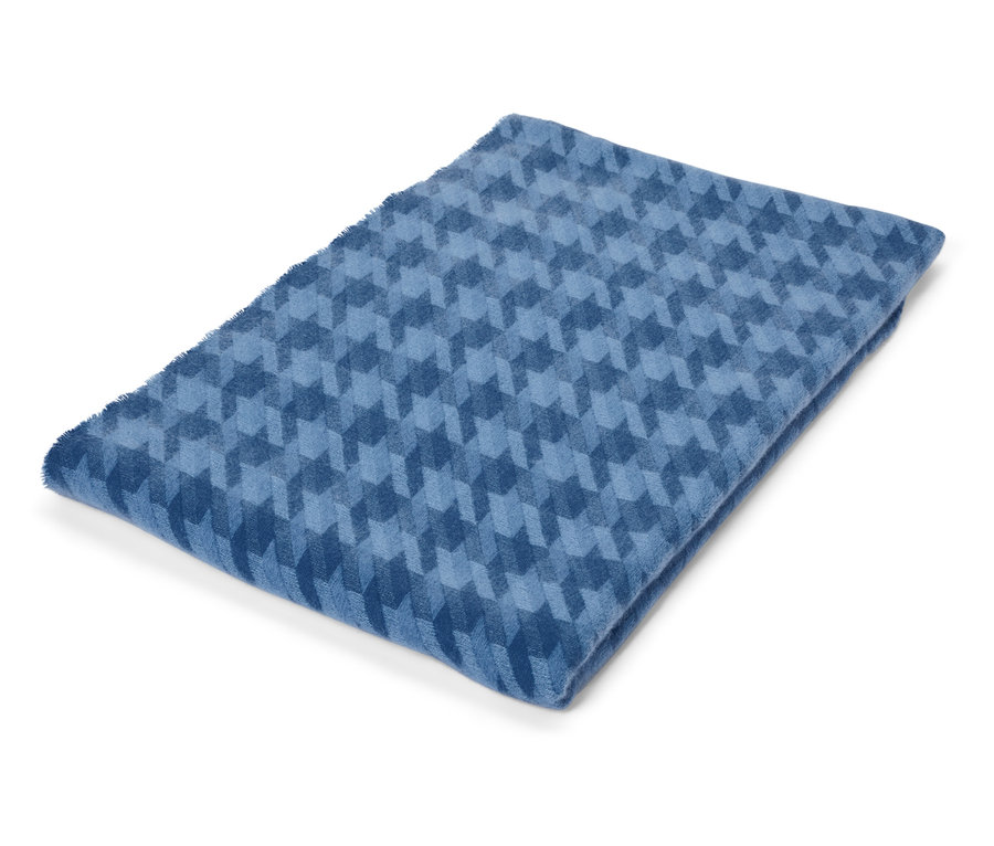 Couverture bleue pliée avec un motif géométrique.