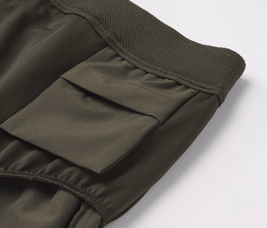 Détail d'un pantalon cargo vert olive avec poche.