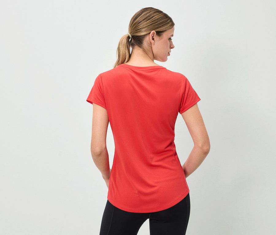 Une femme vue de dos porte un t-shirt rouge et un legging noir.