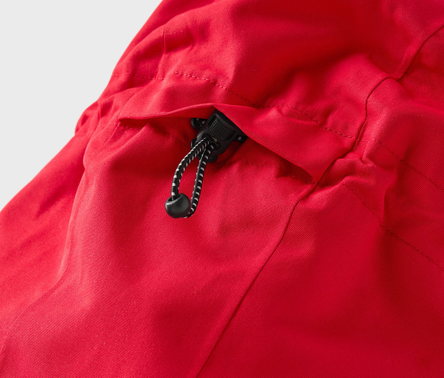 Détail d'une veste rouge avec capuche et cordon de serrage.