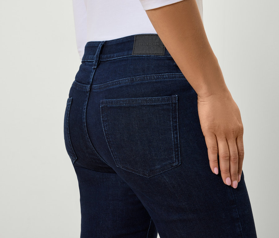 Vue détaillée de l'arrière d'une femme portant un jean bleu moulant.