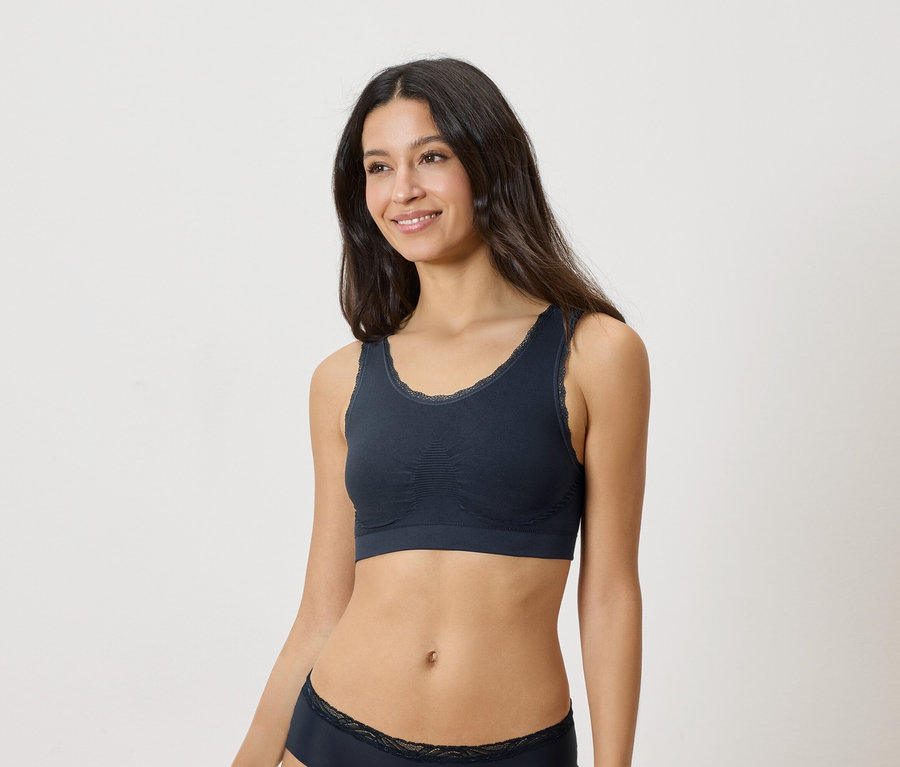 Femme portant un soutien-gorge bleu marine avec des détails en dentelle et des sous-vêtements assortis.