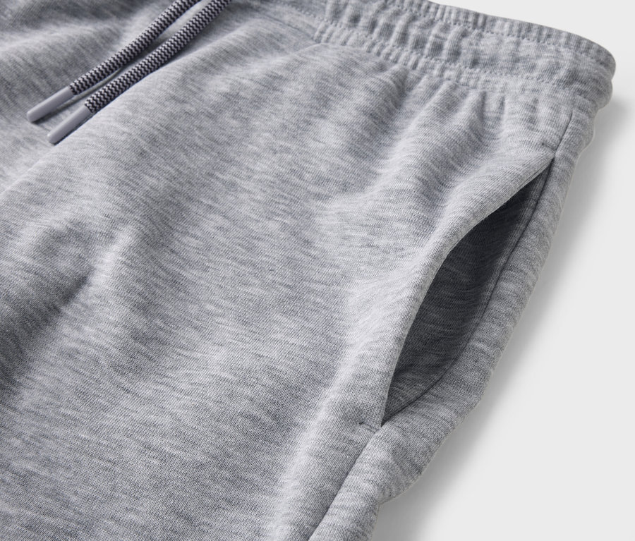 Gros plan d'un pantalon de jogging gris avec cordon de serrage et poche.