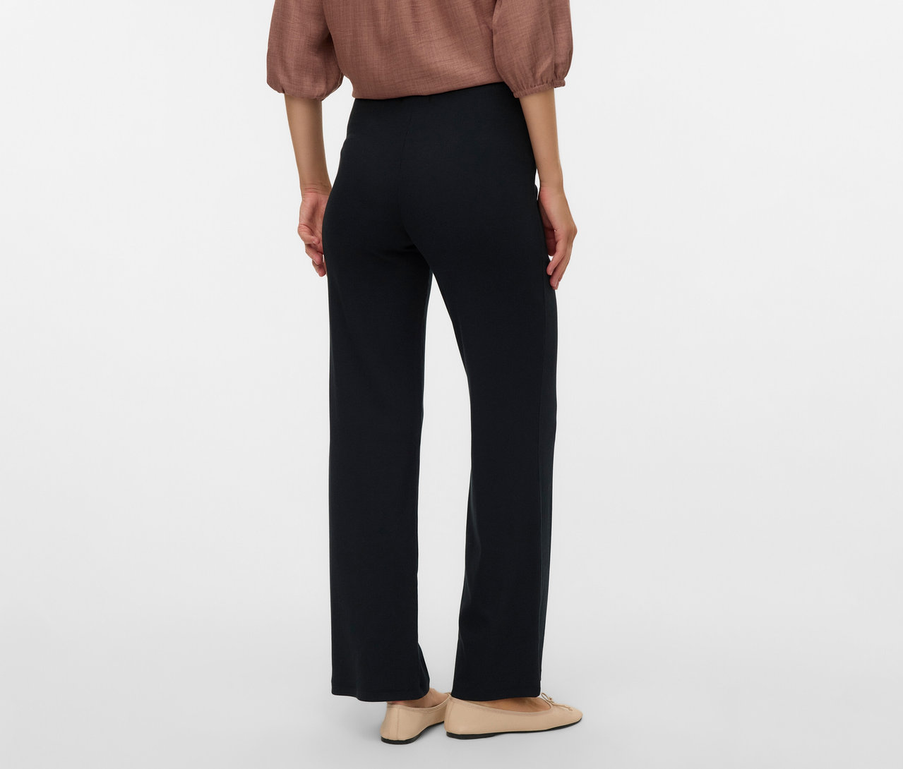 Vue arrière d'une femme portant un chemisier marron et un legging décontracté noir MAMALICIOUS «
MLEMILY », avec des ballerines beiges.