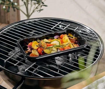Légumes dans un plat noir sur un barbecue.