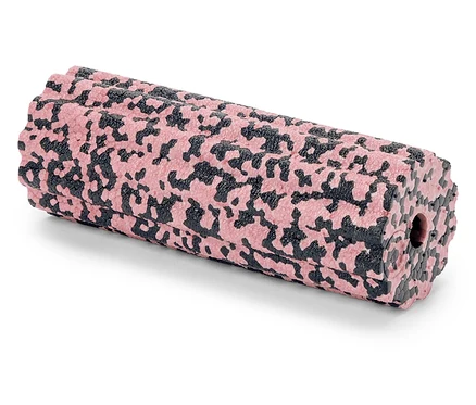 Un rouleau de massage à motifs roses et noirs est posé sur une surface blanche.