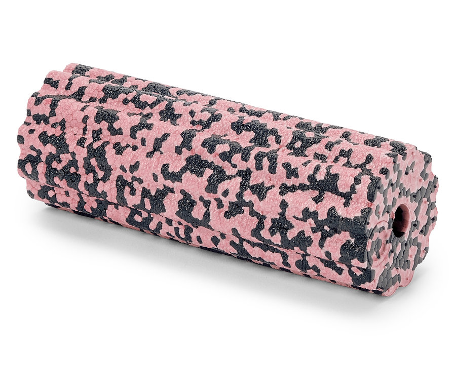 Un rouleau de massage à motifs roses et noirs est posé sur une surface blanche.