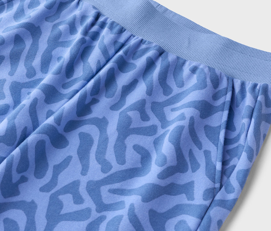 Gros plan d'un pantalon bleu clair avec un motif abstrait.