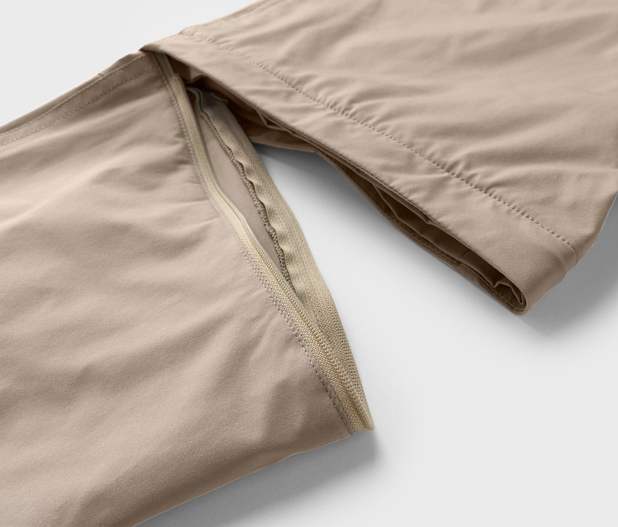 Gros plan d'un pantalon beige avec détail de fermeture éclair.
