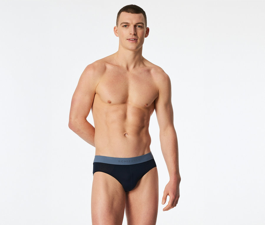 Un homme torse nu porte un slip SCHIESSER noir avec une ceinture grise.