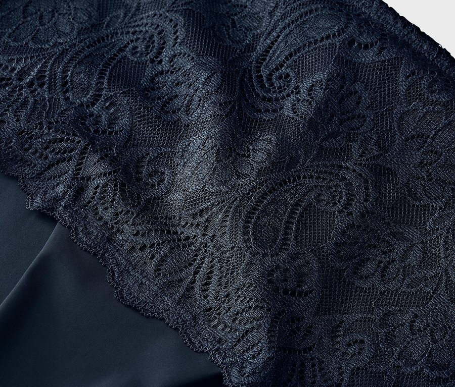 Gros plan de dentelle bleu marine sur un tissu bleu marine.