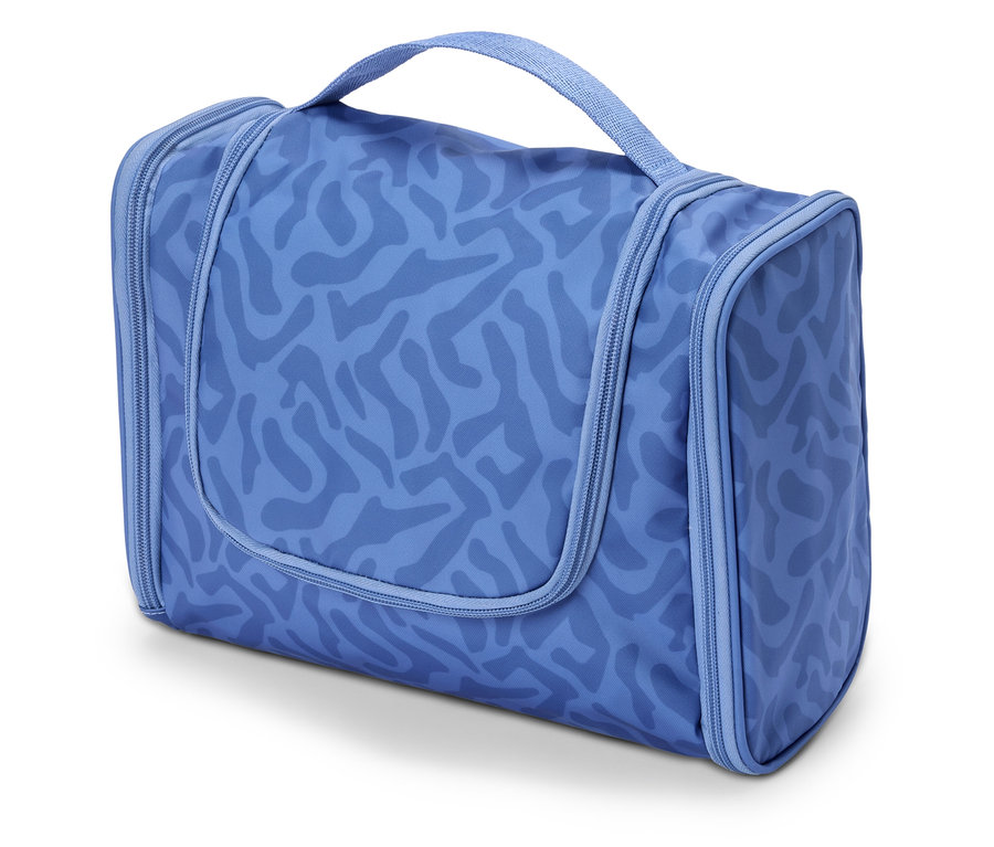 Une trousse de toilette bleue à motifs posée sur une surface blanche.