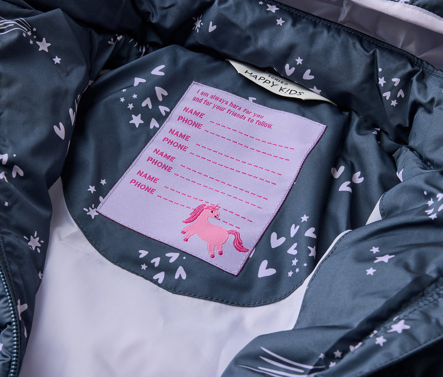 Vue intérieure d'une veste bleu foncé Tchibo HAPPY KIDS avec des étoiles et des cœurs, avec une étiquette pour le nom et le numéro de téléphone avec une licorne.